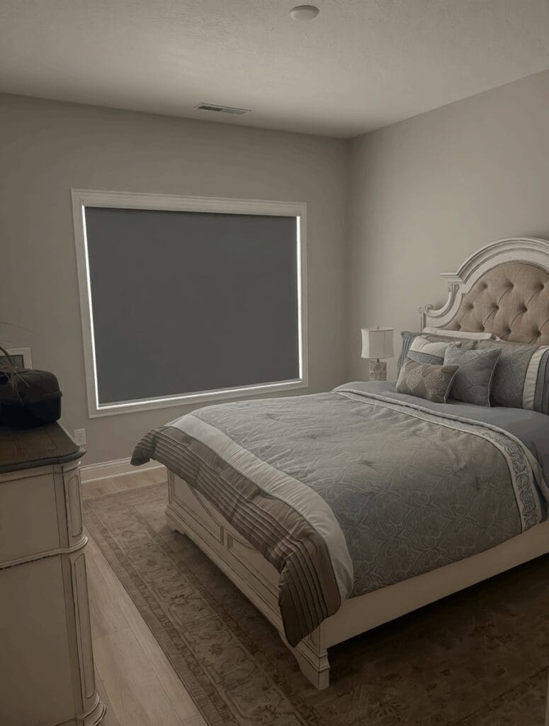 A bedroom is darkened by the blackout shades on the window.